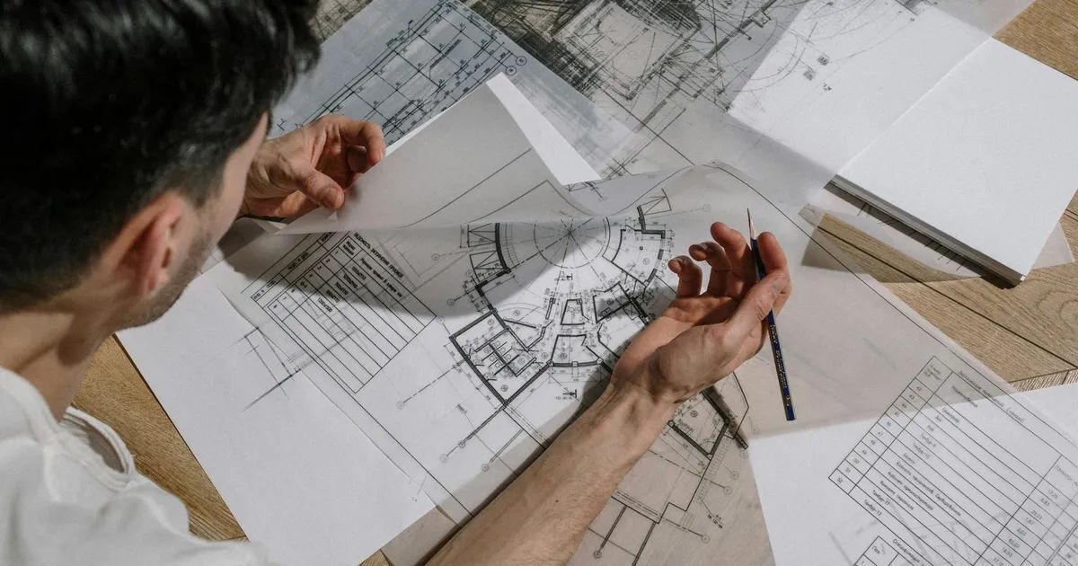 Architecte étudiant des plans détaillés illustrant le processus de création d'un site web sur mesure