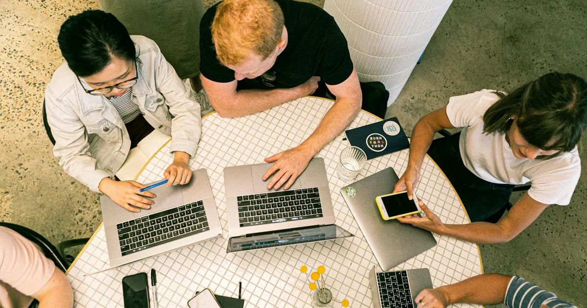 Professionnels travaillant ensemble sur un ordinateur portable pour améliorer leur stratégie digitale