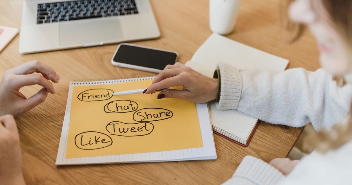 Entrepreneure gérant les réseaux sociaux de sa petite entreprise sur smartphone et ordinateur