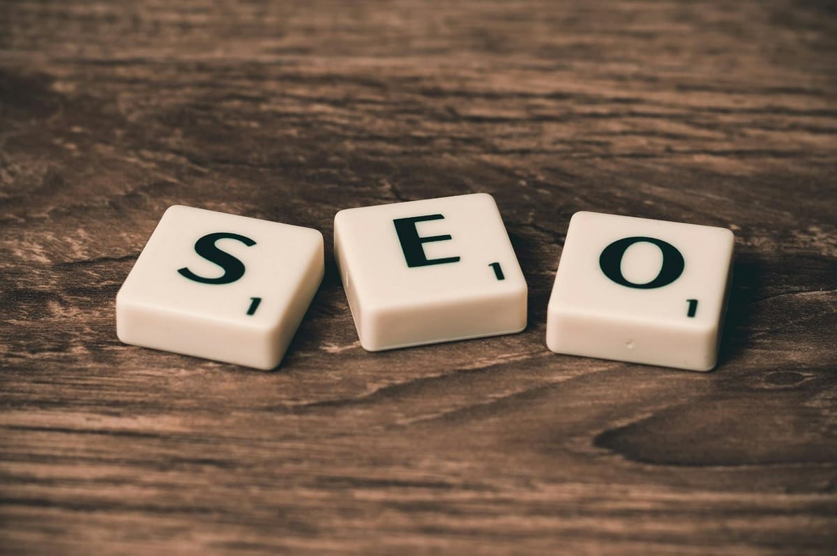 trois lettres Scrabble formant le mot SEO posées sur une planche en bois sombre